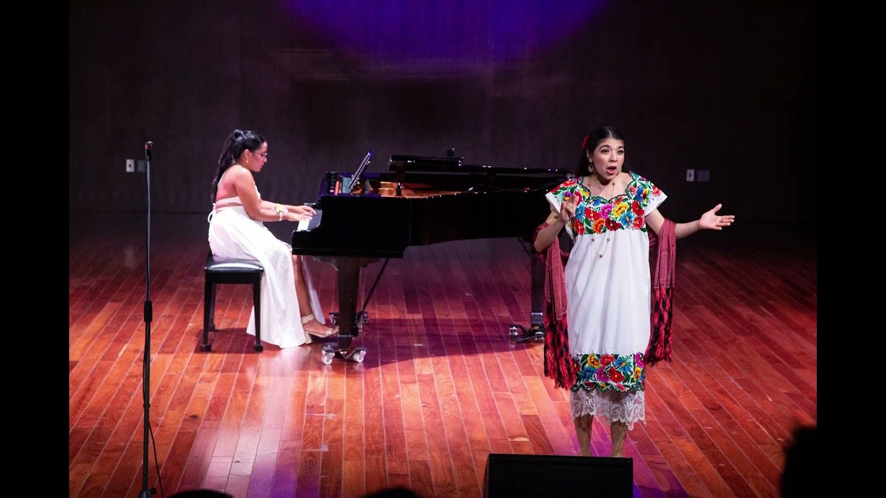 Raíces Entrelazadas en el Palacio de la Música: Blanca Fuentes al piano y la cantante en traje regional