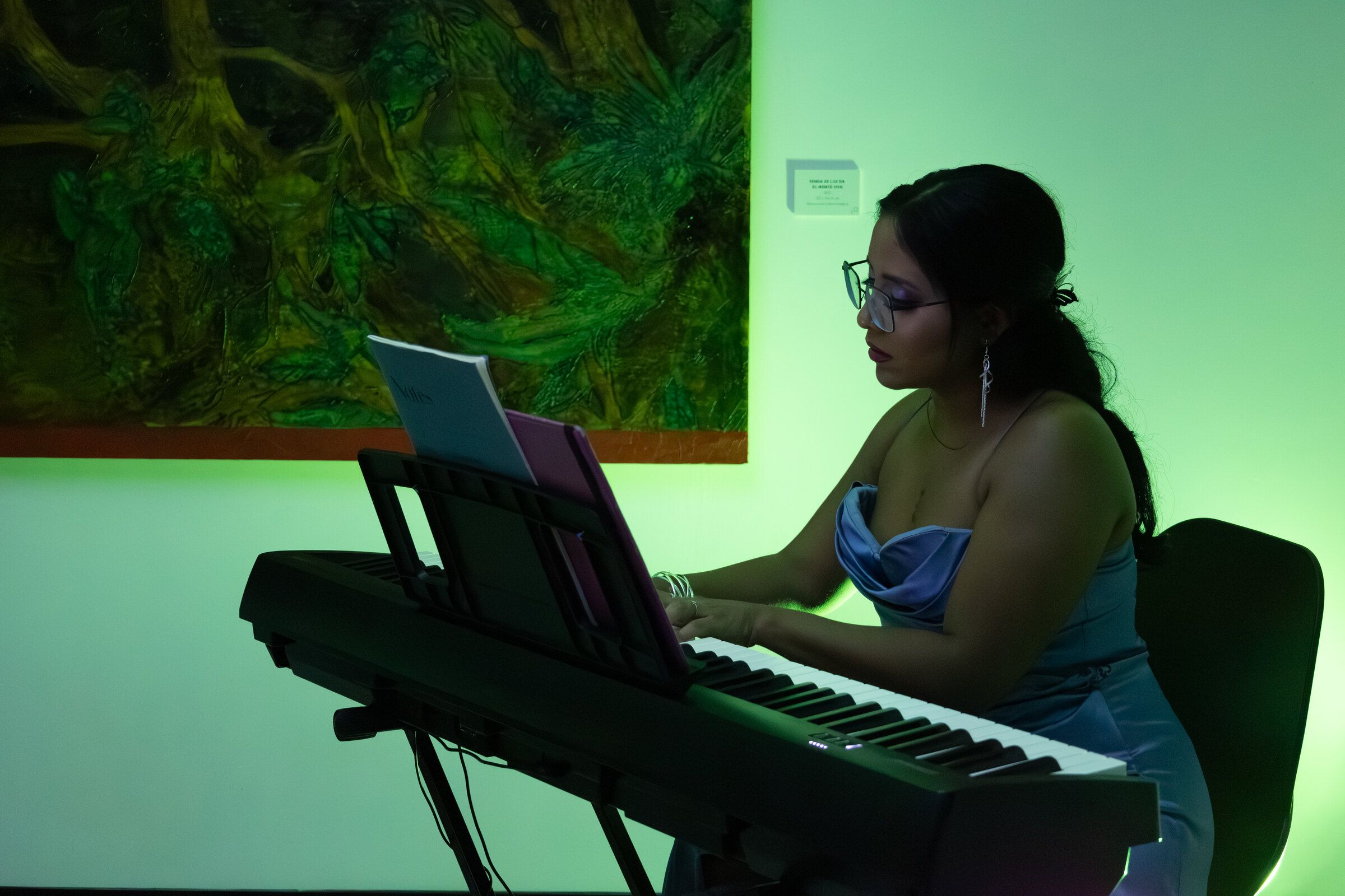 Blanca Fuentes toca un teclado bajo luz verde